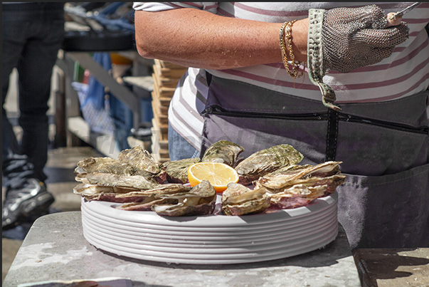At the port of Cancale, oyster farmers sell freshly harvested oysters directly to tourists, also preparing tasting dishes