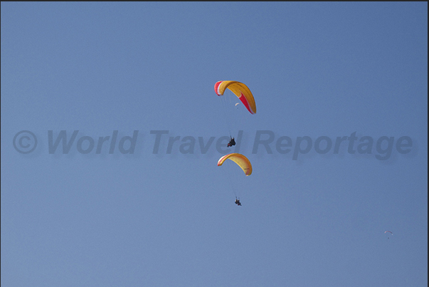 Paraglider flying over the lake