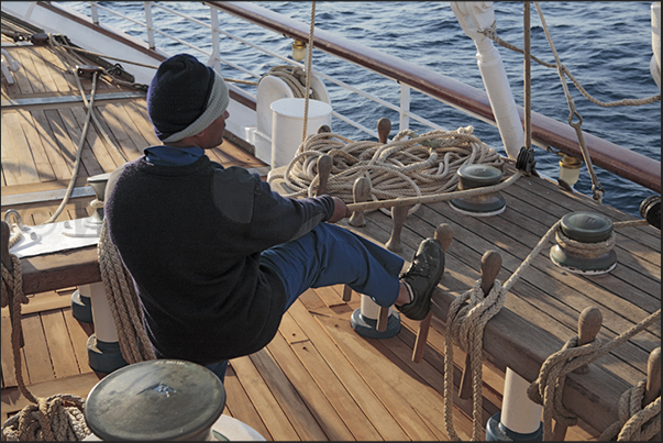 Sailor on the maneuvers of the jibs sails on the bow. During the cruise you can participate, along with sailors, to hoist the sails