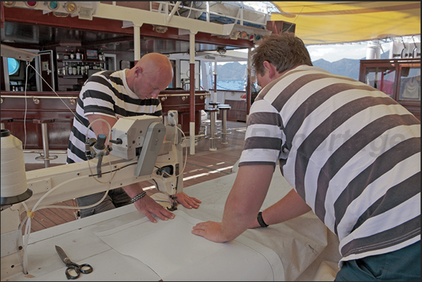 During the night, the wind tore a sail. The next day, the tailors repair the sail with needle and thread