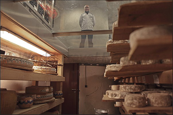 The owner controls the maturing of cheeses in his cellar