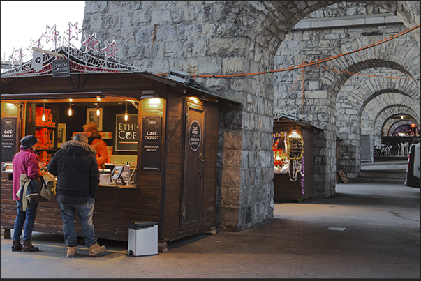 Among the stone arches that line the Europa square, pubs and Christmas stands
