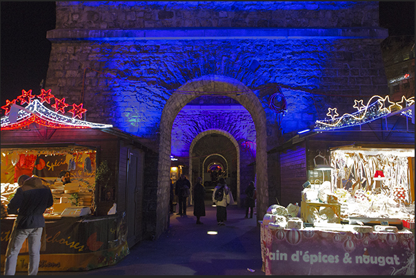 Among the stone arches in the Europa square, pubs and Christmas stands