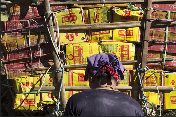 A bearer is preparing to load on his shoulders the load of goods for sale at the village of Namche Bazar (3440 m)