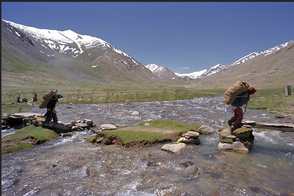 Some nomads crossing the river to bring food to the camp of tents