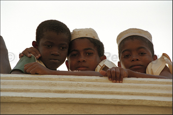 Some children, observe the traffic in the city during a stop of the lessons in a Koranic school