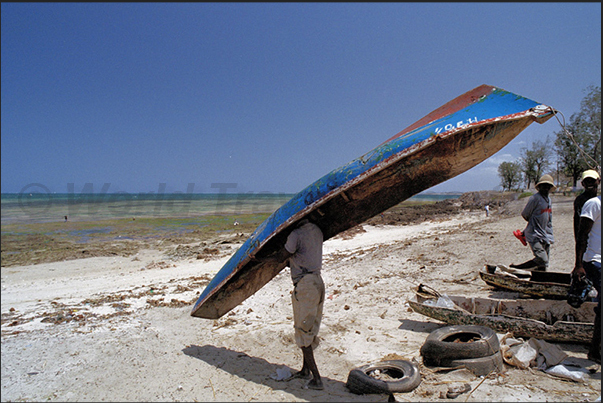 A fisherman performs some simple maintenance to his pirogue